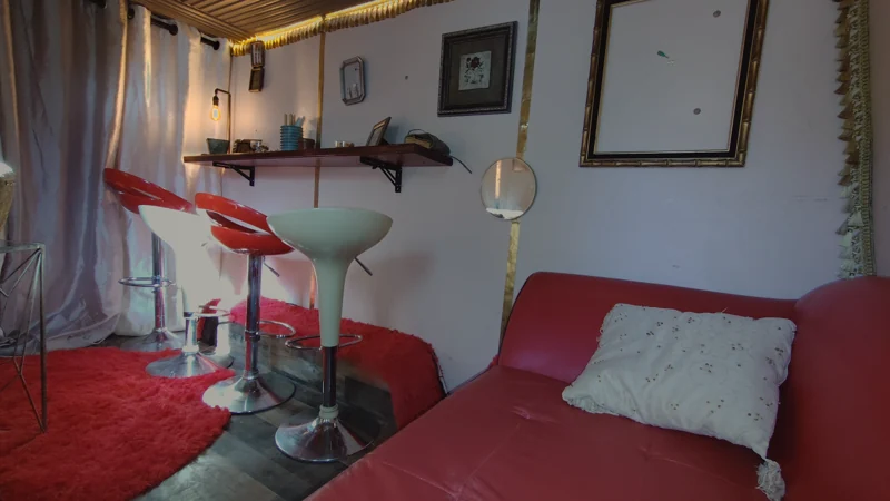Curved red sofa, retro stools, mirrors, and warm accent lights inside the lounge.